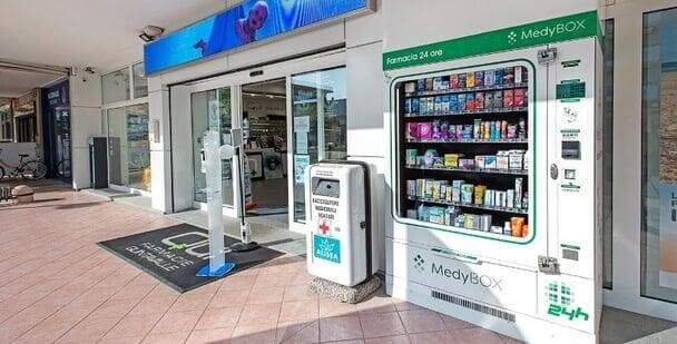 Outdoor MEDBOX pharmacy vending machine located outside a pharmacy, stocked with a comprehensive selection of pharmacy products available for sidewalk purchase by customers